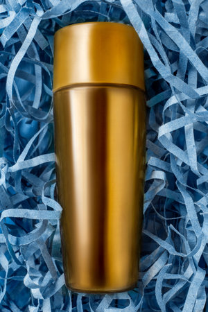 Yellow blank cosmetic product jar lying in blue shredded filling paperの写真素材