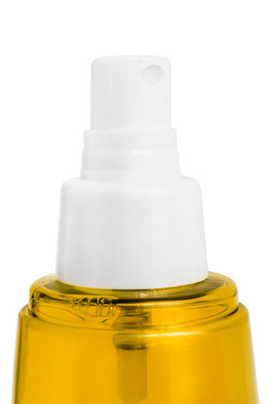 Yellow beauty product bottle spray closeup isolated over whiteの写真素材