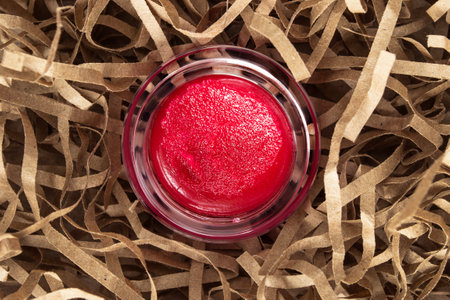Red lip scrub jar in brown shredded filling paperの写真素材
