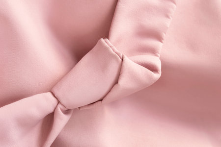 Pastel pink fabric tied knot clothes detail closeup as a backgroundの写真素材