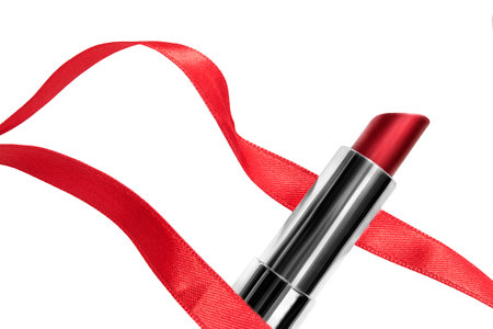 Elegant red lipstick tube with red satin ribbon isolated on white backgroundの写真素材
