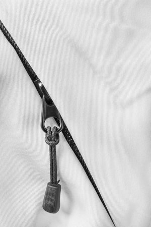 Black clothes zipper in white blank fabric closeup as a backgroundの写真素材