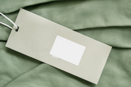 Blank price tag label over khaki green fabric background closeupの写真素材