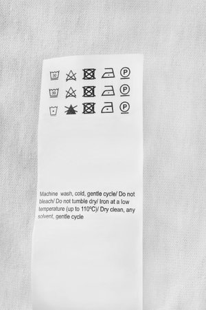 Washing instructions clothes label closeup over white fabric backgroundの写真素材