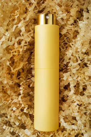 Perfume spray atomizer lying in yellow shredded crinkle packaging paperの写真素材