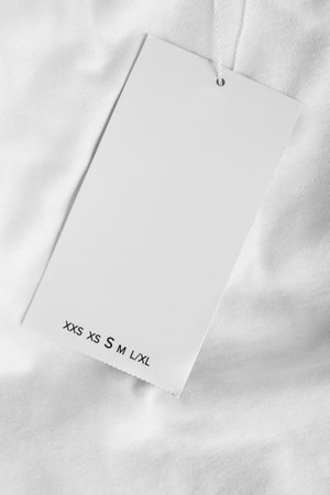 Size S clothes label over white cotton fabric background closeupの写真素材
