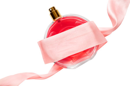 Red perfume glass bottle tied with pink silk ribbon isolated over whiteの写真素材