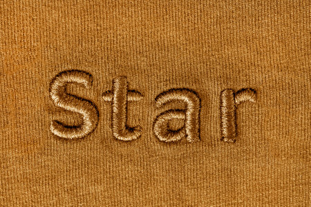 Embroidered word Star on yellow knit fabric background closeupの写真素材