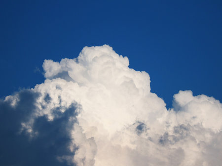 Cumulus cloud highlighted by the sun in the blue skyの写真素材