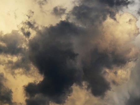 Dark gray and golden clouds highlighted by the sun detailsの写真素材