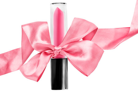 Pink lipstick tube tied with pink satin ribbon bow isolated over whiteの写真素材