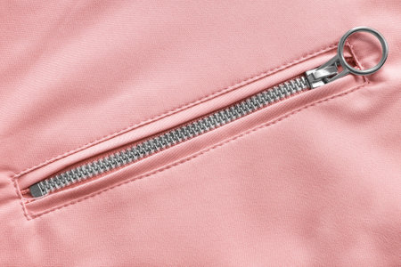 Fastened zip pocket in pastel pink fabric as a backgroundの写真素材