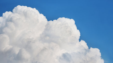 Details of large white cumulus cloud over blue sky closeupの写真素材
