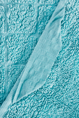 Fabric hanging loop on light blue terry towel closeup as a backgroundの写真素材