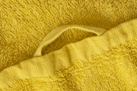 Yellow terry towel hanging loop closeup as a backgroundの写真素材