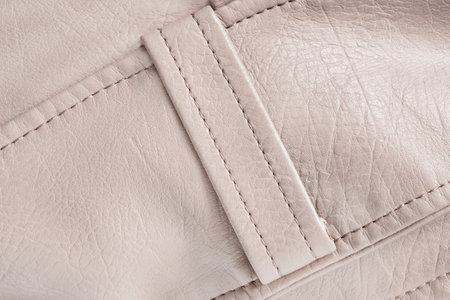 Beige leather stitched belt loop closeup as a backgroundの写真素材