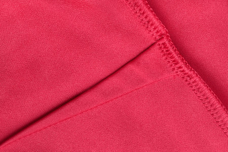 Seam on red fabric closeup as a backgroundの写真素材