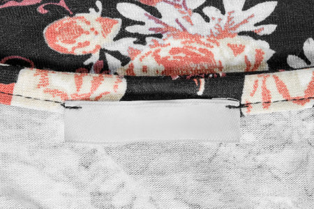 Blank clothes label stitched on white and black knit fabric as a backgroundの写真素材