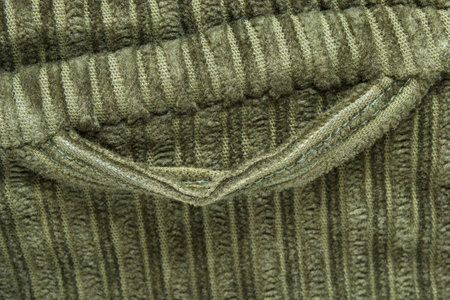Khaki color velvet fabric jacket hanging loop closeup as a backgroundの写真素材