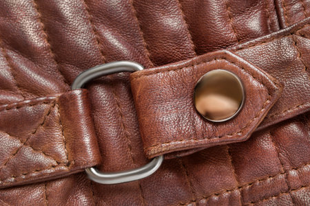 Brown leather jacket belt with a snap button details closeup