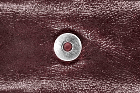 Metallic snap button on burgundy color leather backgroundの写真素材