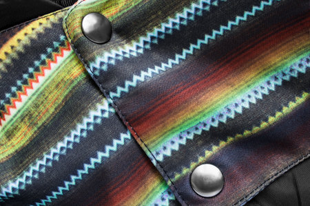 Clothes snap buttons on colorful fabric closeup as a backgroundの写真素材