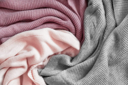 Gray and pink draped knit wool fabric closeup as a background