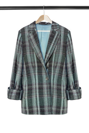 Elegant oversized wool jacket hanging on clothes rack isolated over whiteの写真素材