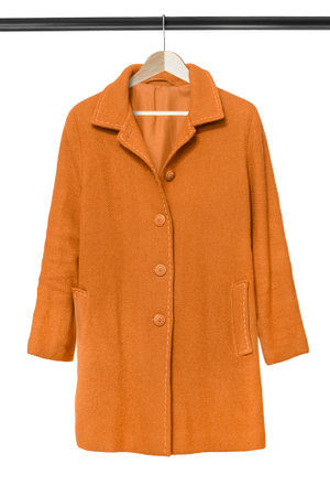 Yellow wool coat hanging on clothes rack isolated over whiteの写真素材