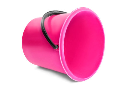 Empty pink plastic bucket lying on white backgroundの写真素材