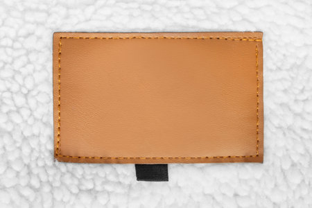 Blank leather patch label stitched on white fleece backgroundの写真素材