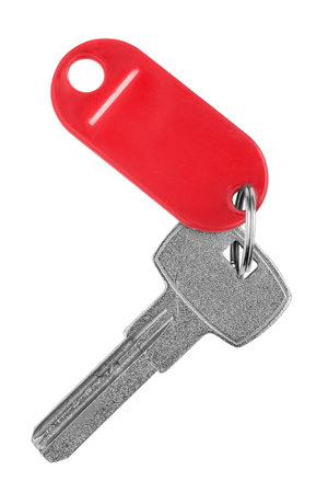 Steel door key with red plastic key tag trinket isolated on white backgroundの写真素材