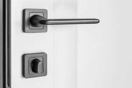 Black door handle and lock on white door closeupの写真素材