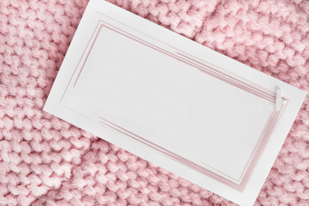 Blank price tag label over pastel pink knit wool fabric background closeupの写真素材