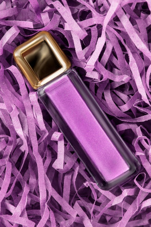 Purple glitter eyeshadows jar lying in shredded filling packaging paper