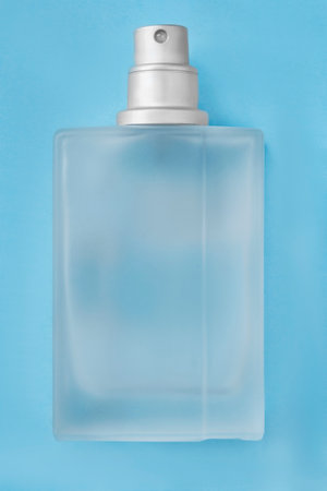 Frosted glass perfume bottle over light blue studio backgroundの写真素材