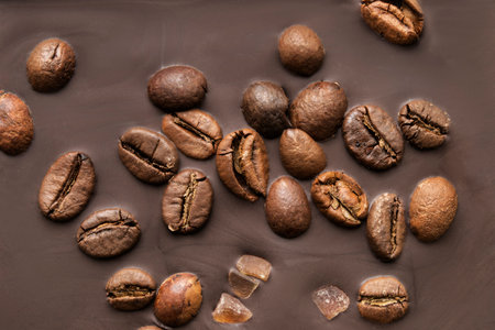 Dark brown chocolate with coffee beans closeup as a backgroundの写真素材
