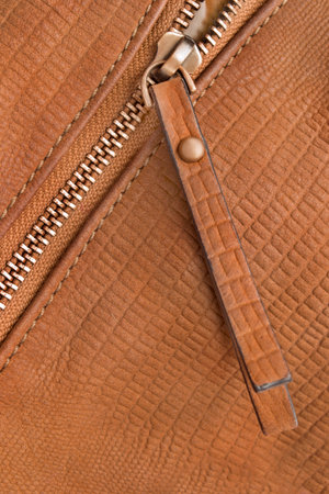 Zipper fastener in brown textured leather closeup as a backgroundの写真素材