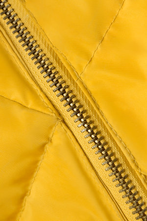 Jacket zipper stitched in yellow waterproof fabric closeup as a backgroundの写真素材