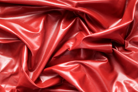 Abstract red draped latex fabric closeup as a backgroundの写真素材