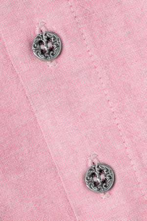 Two small elegant silker buttons on pastel pink cotton shirt closeupの写真素材