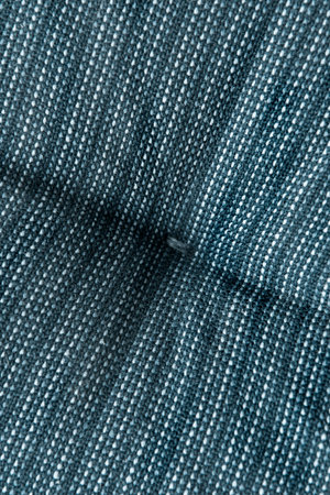 Blue textured quilted upholstery fabric closeup as a backgroundの写真素材