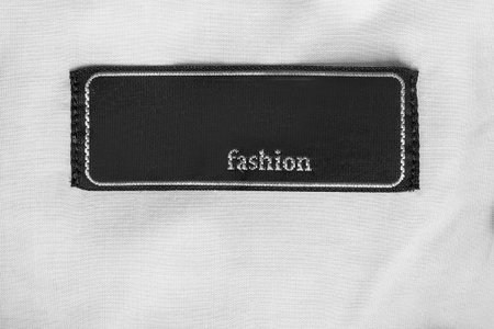 Black clothes patch label text Fashion stitched on white fabric backgroundの写真素材
