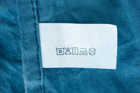 Care instructions clothes label over blue cotton fabric background closeupの写真素材