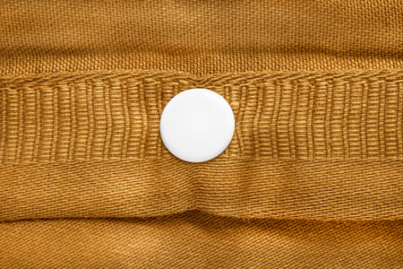 Yellow fabric with white plastic snap button closeupの写真素材