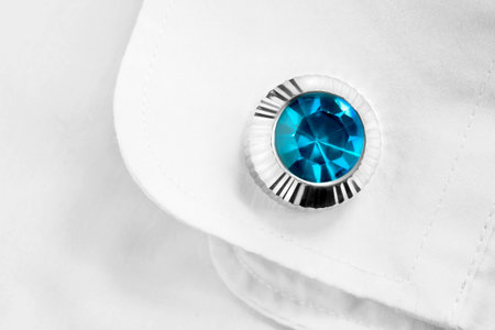 One elegant topaz cufflink on white cotton shirt closeup
