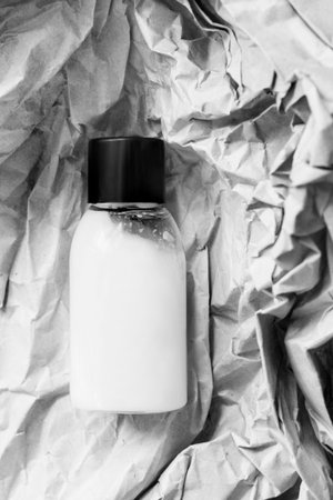 Body care product bottle over white crumpled packaging paper backgroundの写真素材