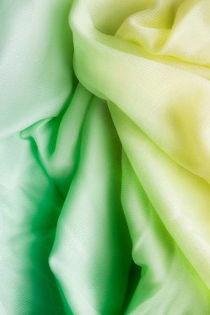 Draped pastel yellow and green chiffon veil closeup as a backgroundの写真素材