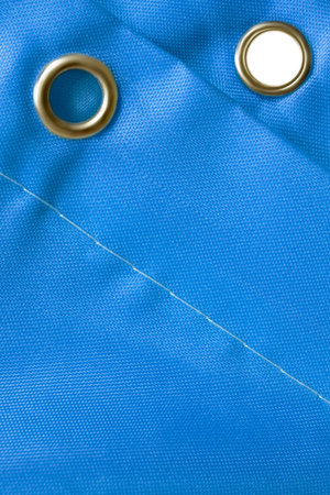 Blue waterproof curtain eyelet rings closeup as a background