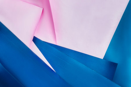 Abstract blue and pink folded paper closeup as a backgroundの写真素材
